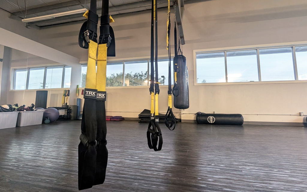 TRX straps and heavy bag hanging in the gym